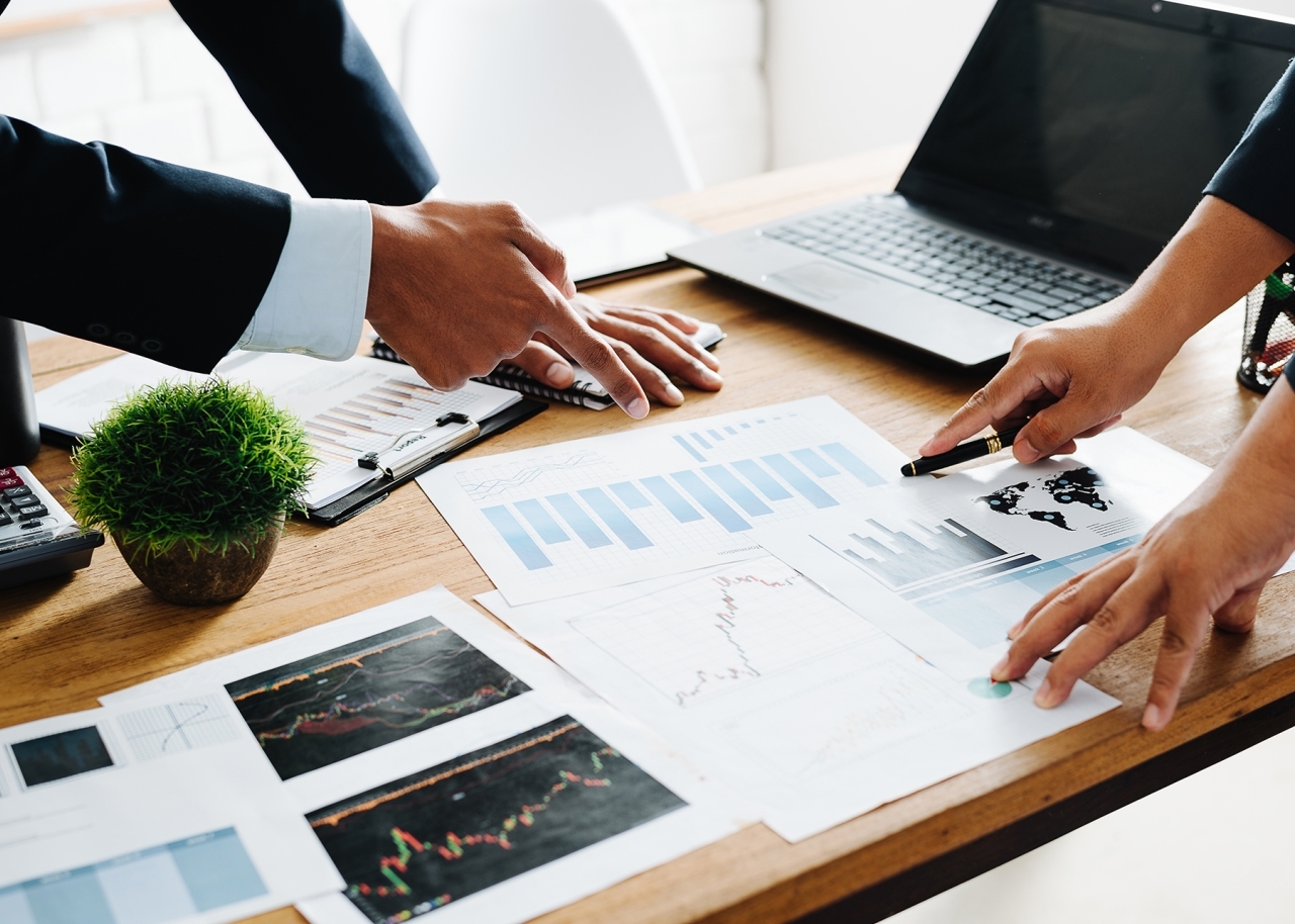 Close up of professionals pointing at charts